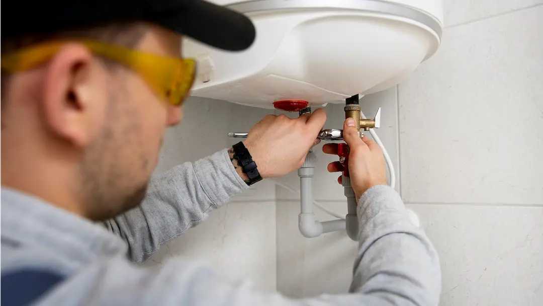 Un technicien intervenant dans l'entretien d'un ballon d'eau chaude.